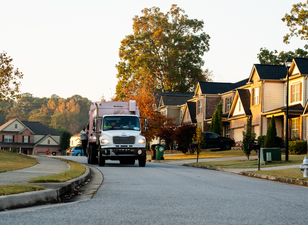 Trash Pickup Truck Driving Through Neighborhood Street
